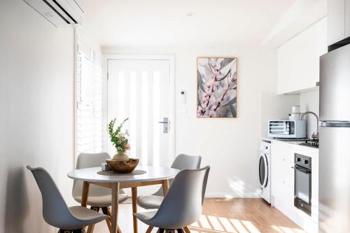 a kitchen and dining room with a table and chairs at The Elm Apartments - The Pink Room in Orange