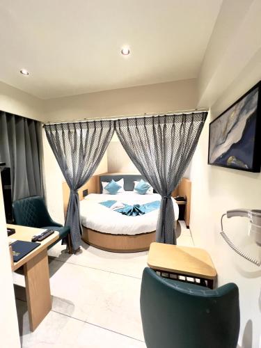 a hotel room with a bed and a desk at Hotel Comfort in Surat