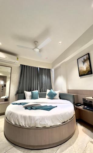 a large bedroom with a large bed with blue pillows at Hotel Comfort in Surat