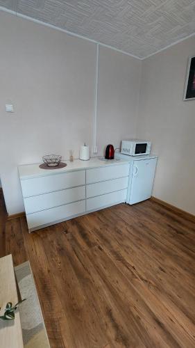 a white kitchen with a counter and a microwave at "Veiklus Rietavas" apgyvendinimas in Rietavas