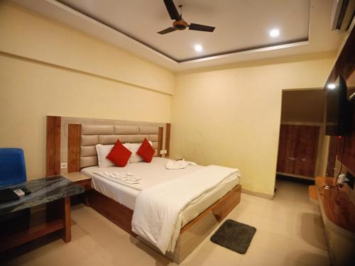 a bedroom with a bed with red pillows and a ceiling fan at Ricardo Beach Resort in Mandarmoni