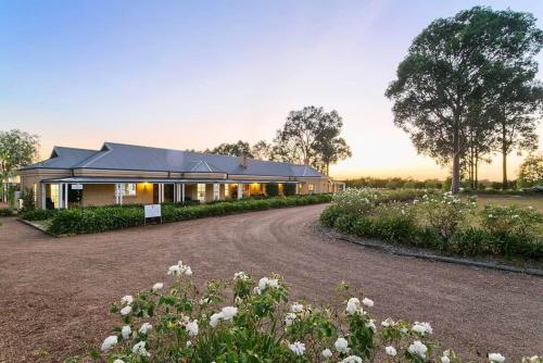 a house with a gravel road in front of it at Vinden Estate Homestead, Pokolbin in Pokolbin