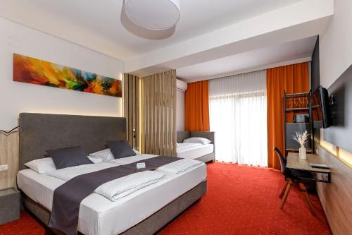 a hotel room with two beds and a television at Vitalhotel Krainz in Loipersdorf bei Fürstenfeld