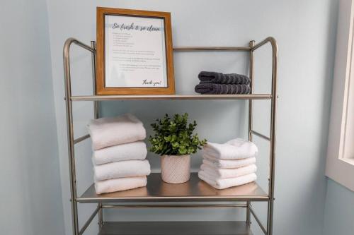 a towel rack with towels and a picture on it at Quiet Area Near Downtown Walkable To Cafes in Maple Ridge District Municipality