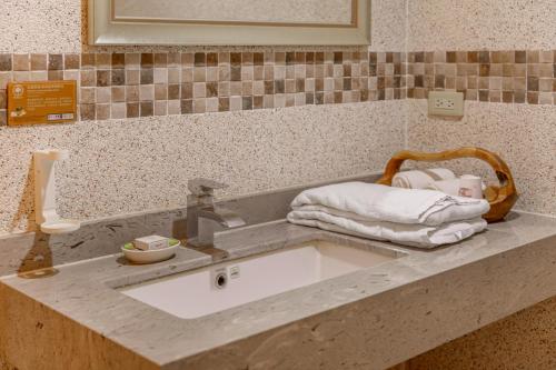 a sink with towels and a basket on a counter at Zhe Juan Meng Tian in Sanyi