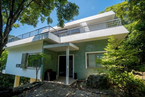 a house with a balcony on top of it at Guesthouse 湯本見山 in Hakone