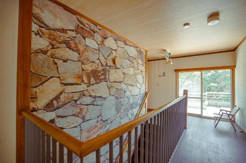 a stone wall in a room with a staircase at Guesthouse 湯本見山 in Hakone