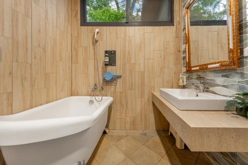 a bathroom with a white tub and a sink at Zhe Juan Meng Tian in Sanyi