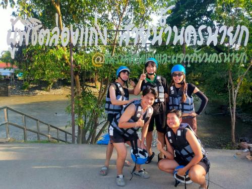 a group of people posing for a picture in front of a river at Chaba1 in Nakhon Nayok