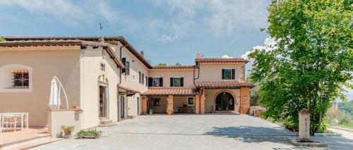 an exterior view of a house with a driveway at Tenuta Alela in Figline Valdarno