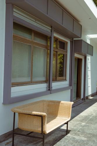 a wicker bench sitting in front of a building at Guesthouse 湯本見山 in Hakone