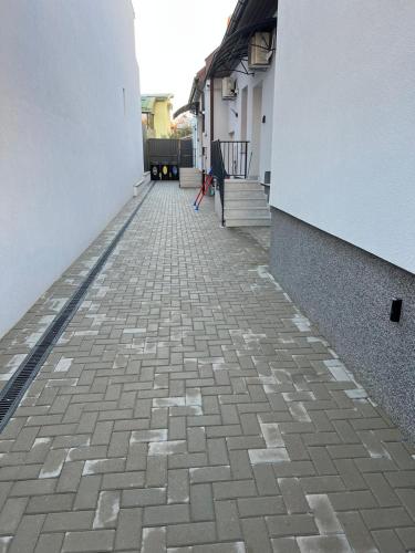 an empty alley with a brick walkway between two buildings at Carina Guest House in Turda