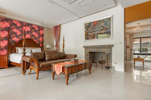 a bedroom with a bed and a couch and a fireplace at Zhe Juan Meng Tian in Sanyi