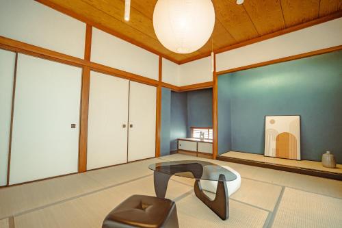 a living room with a table and a chair at Guesthouse 湯本見山 in Hakone