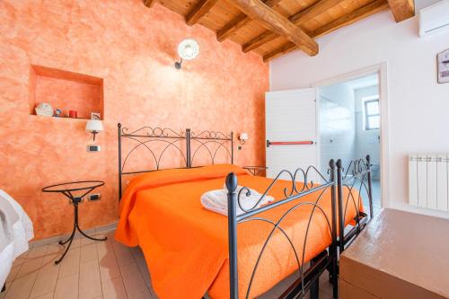 a bedroom with an orange bed in a room at Antico Casale Gioiosa Marea in Gioiosa Marea
