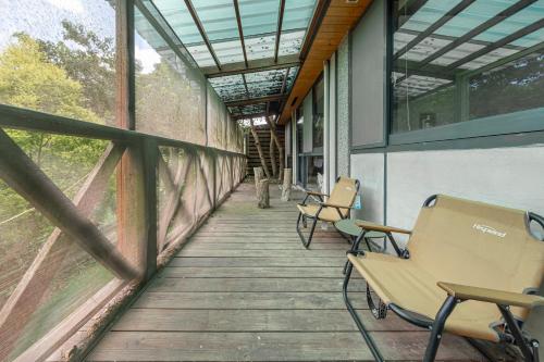 a porch of a building with chairs and windows at Zhe Juan Meng Tian in Sanyi