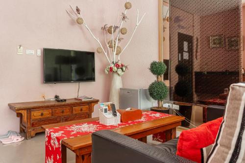 a living room with a table and a tv at Zhe Juan Meng Tian in Sanyi