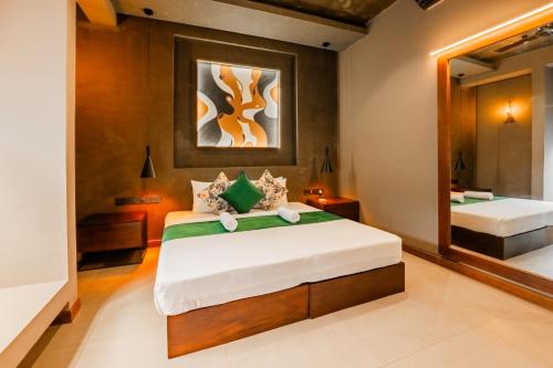 a bedroom with two beds and a mirror at West nest Bohemian in Negombo