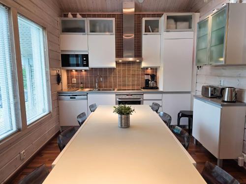 a kitchen with a long table in a room at Villa Chalet - 10 hlö, Himos Länsihuippu in Jämsä