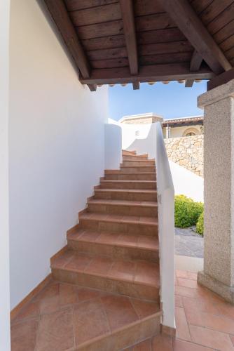 a staircase leading up to a house with a wooden ceiling at Villa Paradisu in Alghero