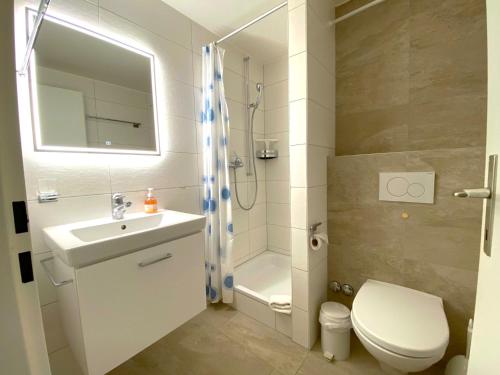 a bathroom with a sink and a shower and a toilet at Adler 82 in Leukerbad