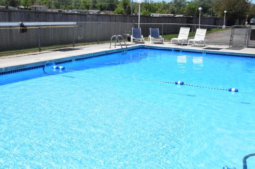 una gran piscina azul con sillas. en National 9 Inn Gillette, en Gillette