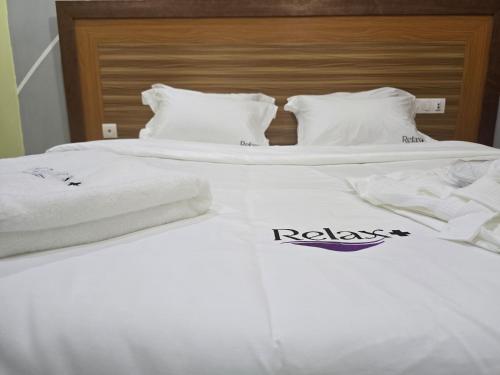 two beds with white sheets and towels on them at STUDIO RELAX plus in Douala