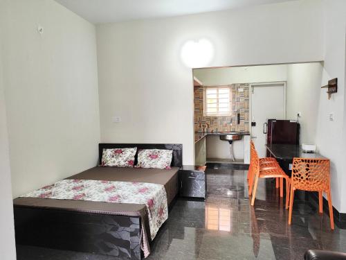 a bedroom with a bed and a table and chairs at Samuels Comfort Homes in Bengaluru