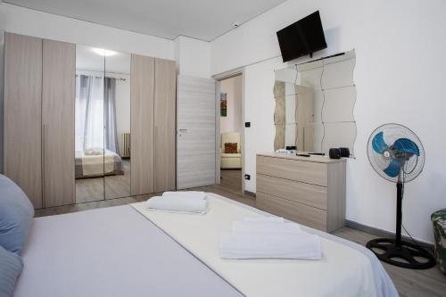 a white bedroom with a large bed and a mirror at PARISI - VERONA Santa Lucia in Verona