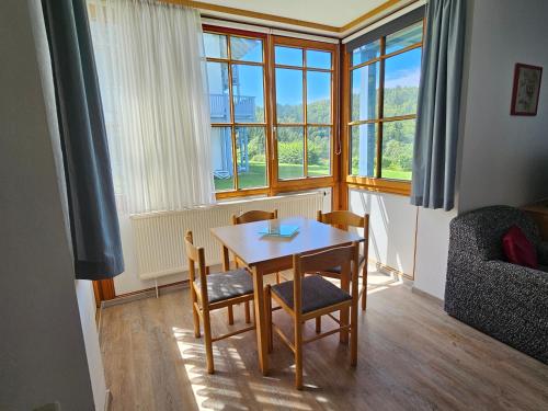 ein Esszimmer mit einem Tisch und Stühlen vor einem Fenster in der Unterkunft Ferienland Sonnenwald Ferienwohnung im Sonnenwald Apartment 5 in Langfurth 