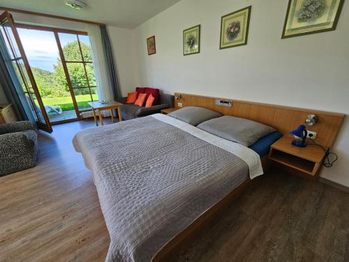 ein Schlafzimmer mit großem Bett und ein Wohnzimmer in der Unterkunft Ferienland Sonnenwald Ferienwohnung im Sonnenwald Apartment 5 in Langfurth 