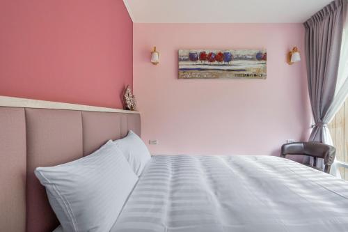 a bedroom with a bed and a painting on the wall at Zhe Juan Meng Tian in Sanyi