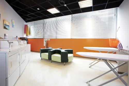 a living room with a table and chairs and a kitchen at Holiday Inn Express Taichung Park by IHG in Taichung