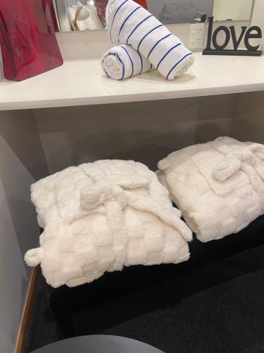 two white towels sitting on a shelf in a store at Hanmer Springs Scenic Views Motel in Hanmer Springs