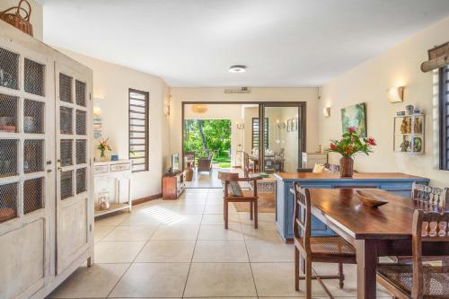a dining room with a table and some chairs at Villa du Lagon, à 50m de la plage avec piscine privée in Roches Noires