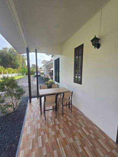 a patio with a wooden table and two benches at Chaba1 in Nakhon Nayok