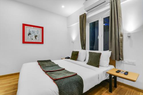 a white bed in a room with a window at Townhouse Welcome INN in Chennai