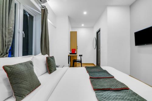 a bedroom with a large white bed with two pillows at Townhouse Welcome INN in Chennai
