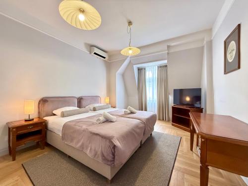 a bedroom with a bed and a table and a desk at Hotel - Pokoje i Apartamenty Heban in Toruń