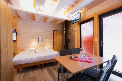 a bedroom with a bed and a table and chairs at Wellness rezort Jánošíkov dvor in Zázrivá