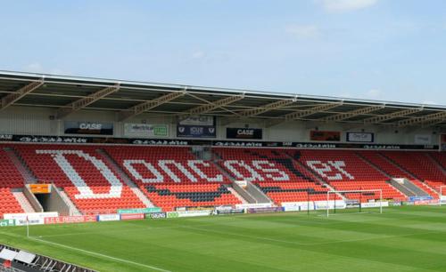 a soccer stadium with red seats and a green field at Hamilton Apartment in Doncaster