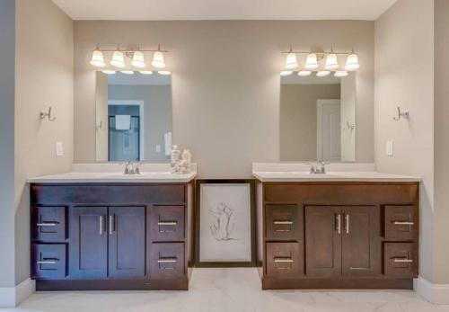 a bathroom with two sinks and two mirrors at Nashville's Music City House, Dolly Approved! in Nashville