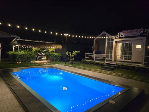a swimming pool lit up at night with lights at Chaba1 in Nakhon Nayok