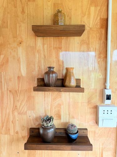 a shelf with vases on a wooden wall at Du peak home in Làng Cac