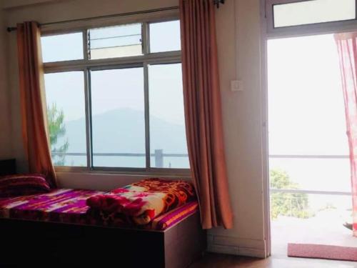 a bed in a room with a large window at Susanta Homestay By StayApart in Pedong