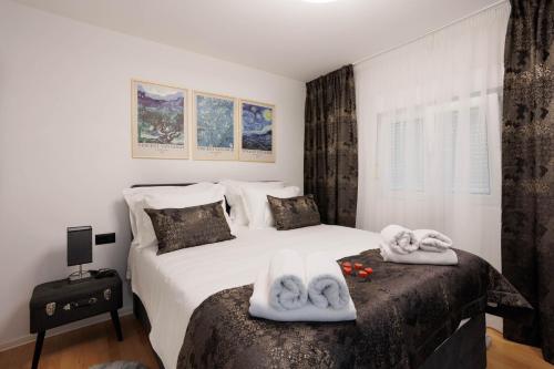 Un dormitorio con una cama con toallas. en Beachfront Villa Marivi with Pool and Game Room, en Podglavica