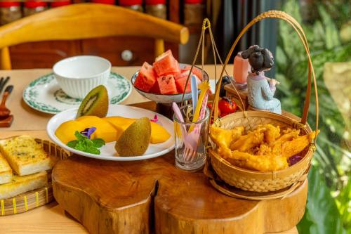 a table with a plate of fruit and a bowl of bread at Zhe Juan Meng Tian in Sanyi