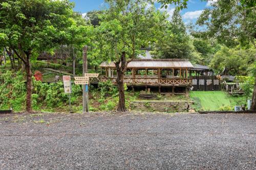a house with a fence and a building with trees at Zhe Juan Meng Tian in Sanyi