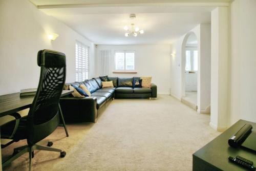 a living room with a couch and a desk at Comfortable Spacious Cottage in Tonbridge