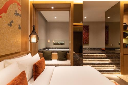 a bedroom with a white bed and a staircase at SOMA HOTEL Riverside in Phnom Penh